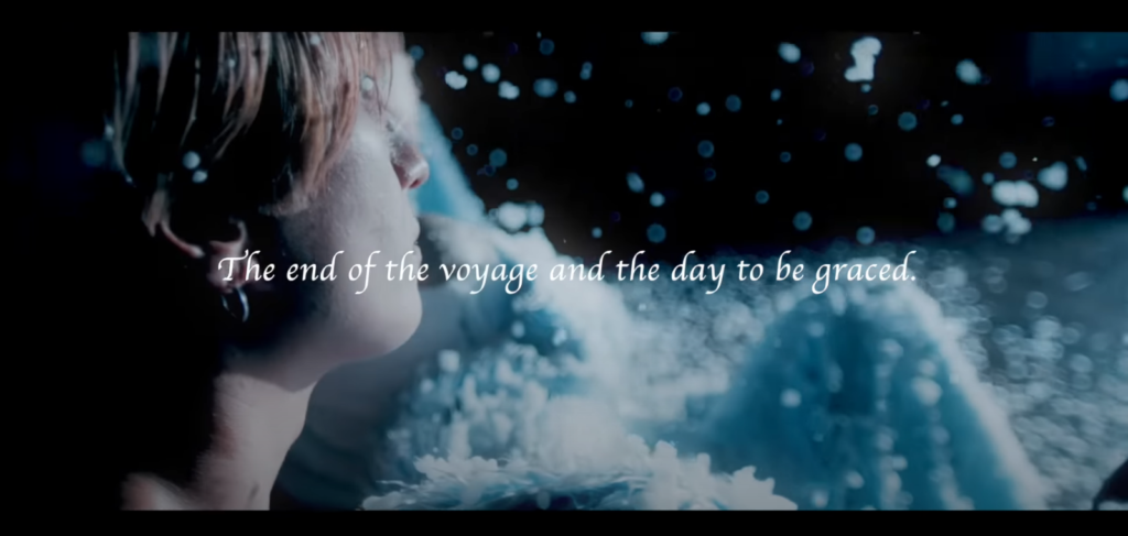 Saga, in profile, looks off to the right in a darkened room in which snow is falling. Overlaid on the image is the phrase, "The end of the voyage and the day to be graced."